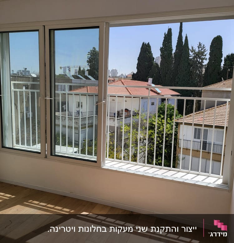 חלונות גדולים עם מסגרות לבנות ומעקה ברזל